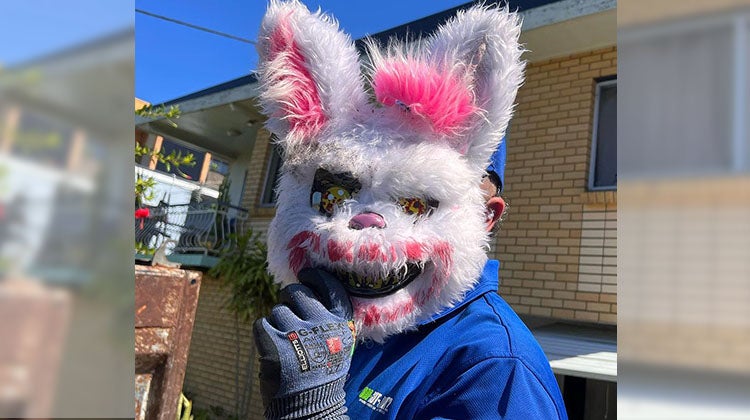 Killre Bunny Head 1-800-GOT-JUNK? truck team member holding a scary bunny mask over face
