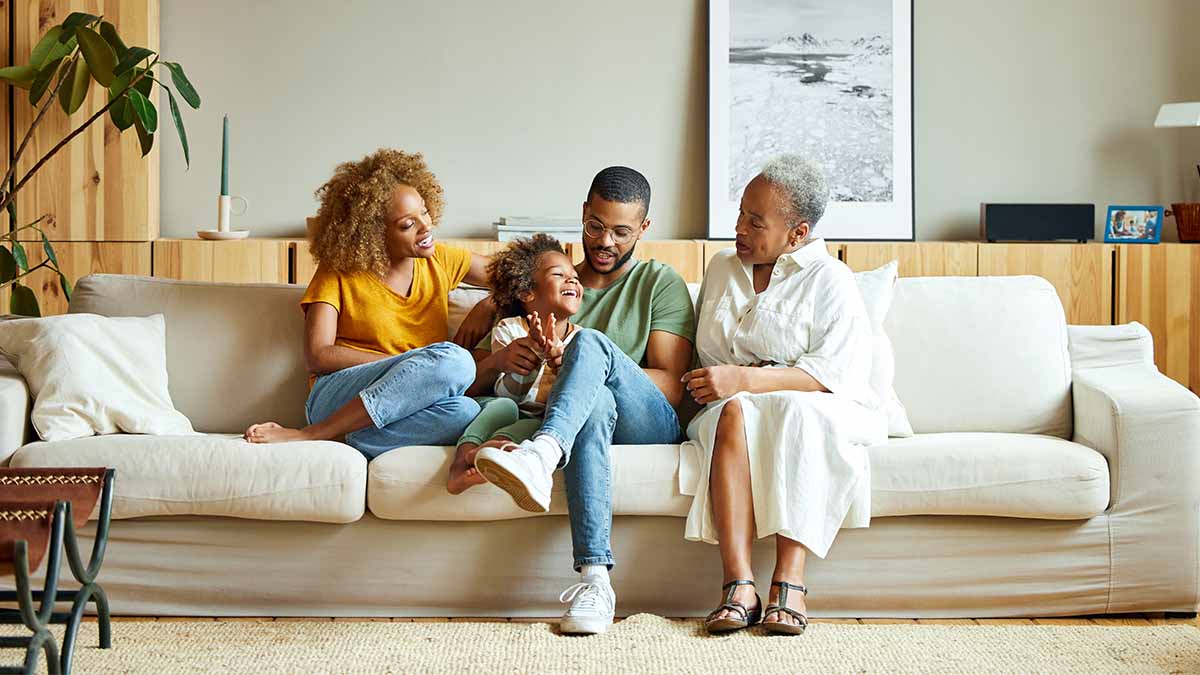 Family of four people sitting comfortable on a large couch Family of four people sitting comfortable on a large couch