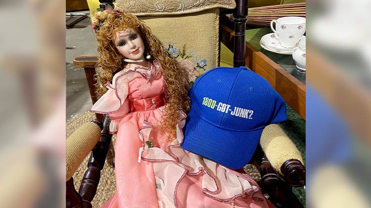 Sleeping beauty doll sitting next to a 1-800-GOT-JUNK? hat Sleeping beauty doll sitting next to a 1-800-GOT-JUNK? hat