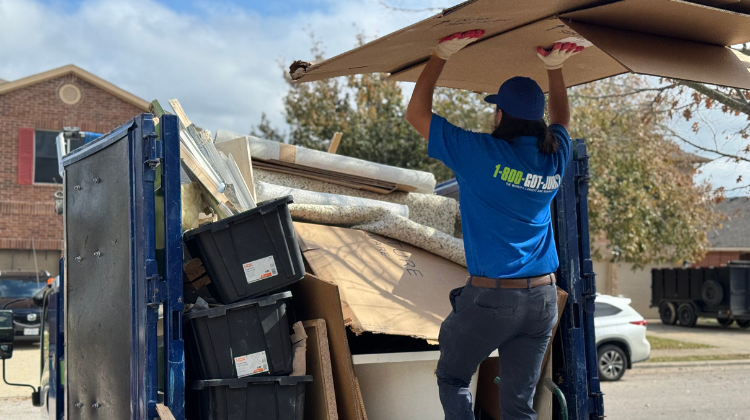 In-blog image 1 - Ruth 1-800-GOT-JUNK? team member loading a large piece of cardboard to a junk removal truck