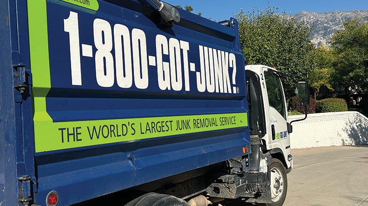 Jordan Page Image 1 Image of a 1-800-GOT-JUNK? truck parked outside a house