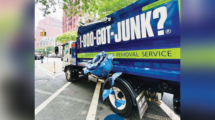 Weird Junk 2024 Giant Rose Giant blue rose leaning agains a 1-800-GOT-JUNK? truck