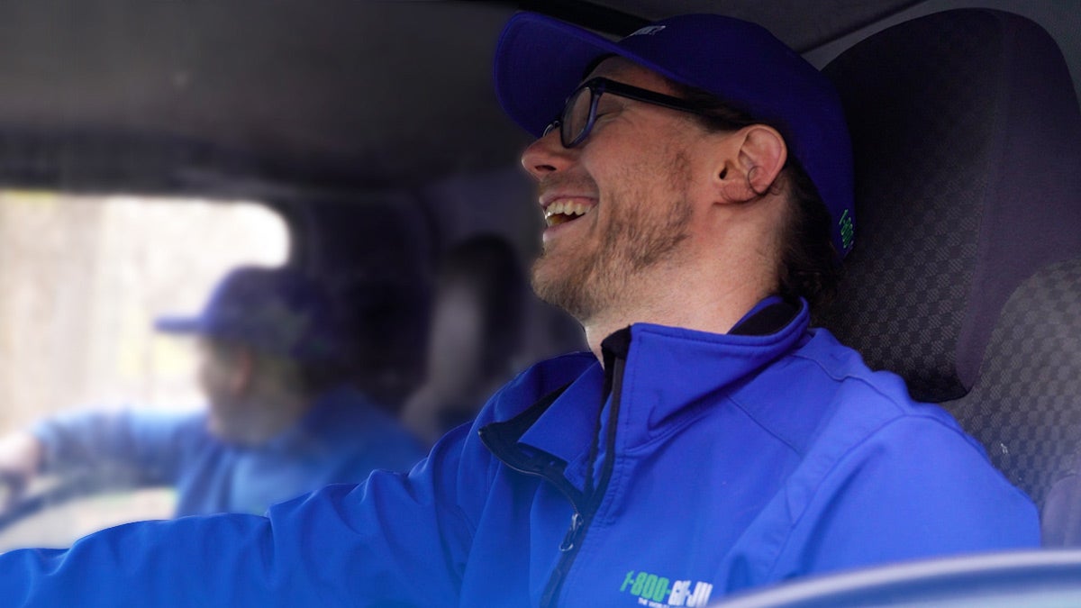 Truck Team Member laughing in a 1-800-GOT-JUNK? truck Truck Team Member laughing in a 1-800-GOT-JUNK? truck