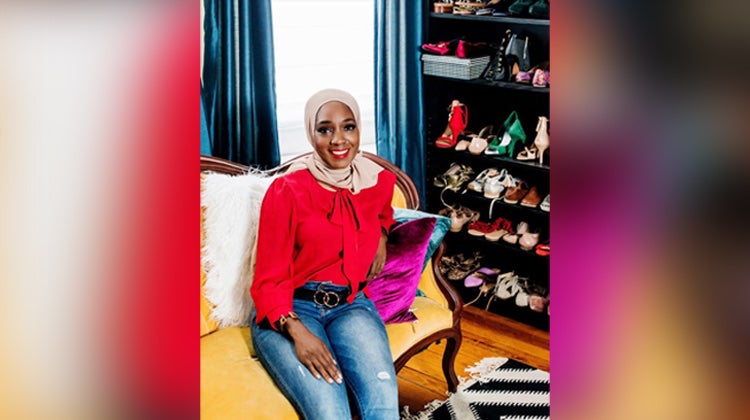 Saudah Saleem in front of a vertical shoe wall Saudah Saleem in front of a vertical shoe wall