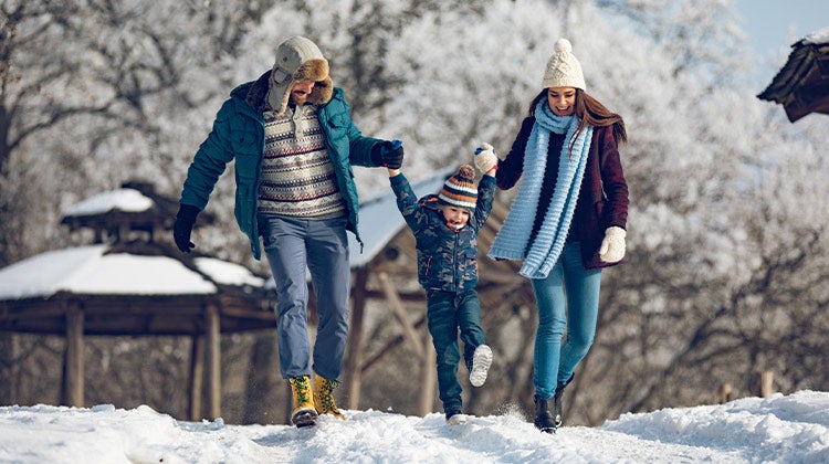 Parents playing with their child in the snow Parents playing with their child in the snow