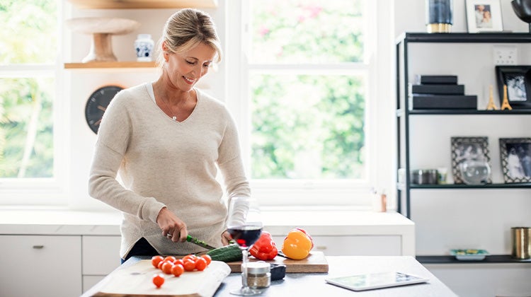 Woman cutting vegetables in her kitchen Woman cutting vegetables in her kitchen