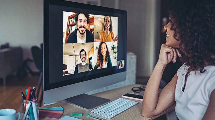 Woman on her computer attending a video event Woman on her computer attending a video event