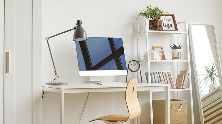 Organized home office with a computer and shelving Organized home office with a computer and shelving