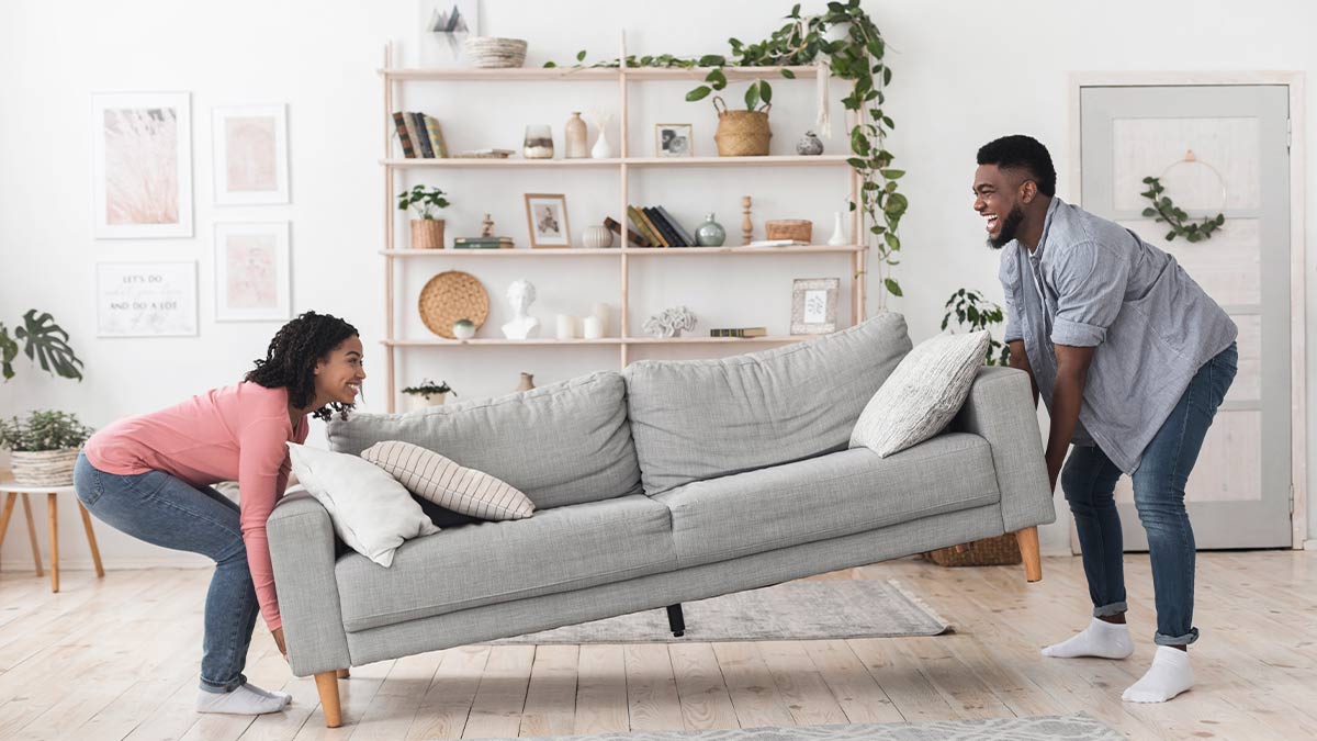couple lifting grey couch couple lifting grey couch
