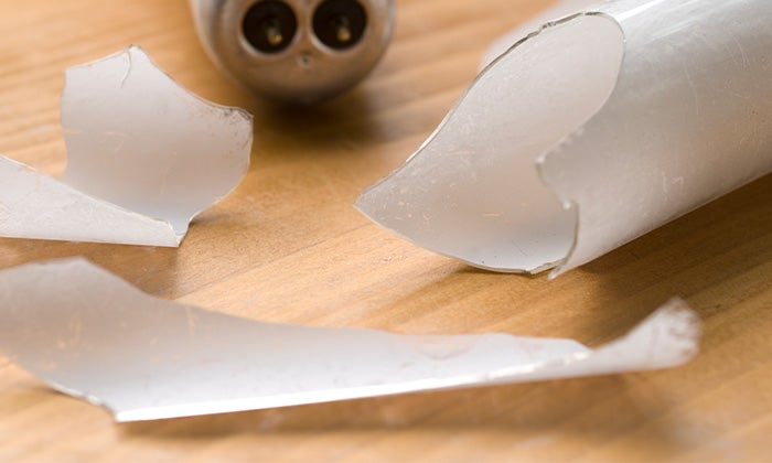 How to dispose of fluorescent tubes Broken fluorescent tube resting on a wooden surface