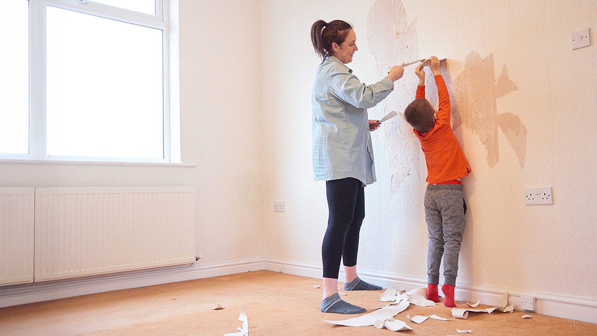 How to remove wallpaper A mother and son face a wall while removing wallpaper