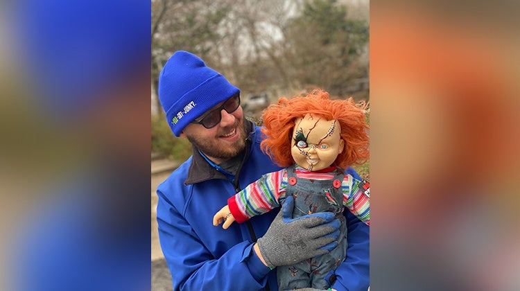 1-800-GOT-JUNK? team member holding a Chucky doll 1-800-GOT-JUNK? team member holding a Chucky doll