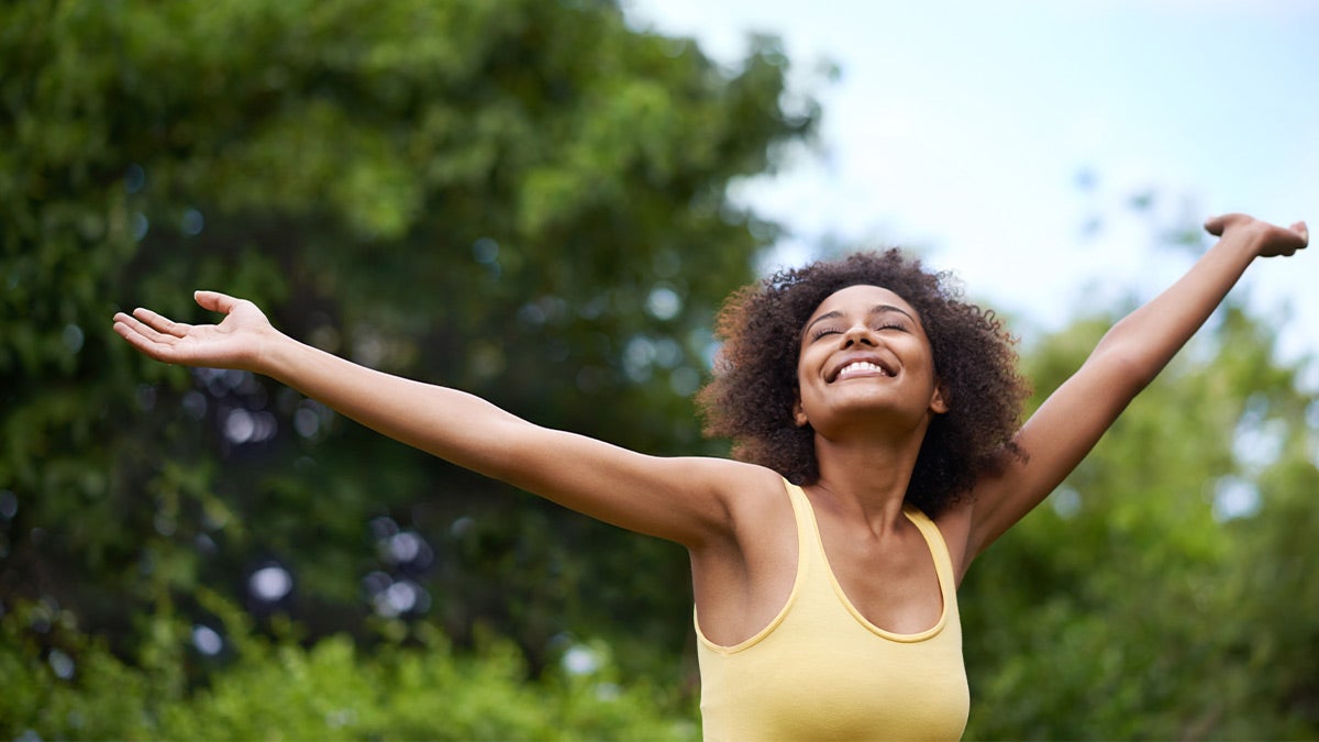 Woman smiling toward the sky outdoors Woman smiling toward the sky outdoors
