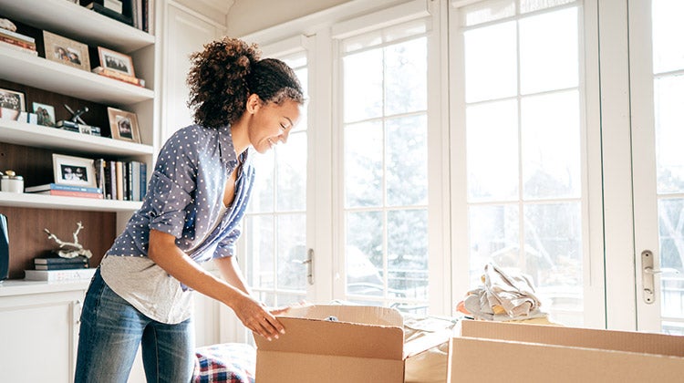 Woman packing up items into boxes Woman packing up items into boxes