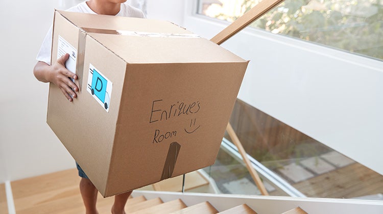 Person holding a labeled moving box Person holding a labeled moving box