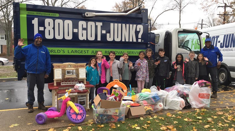 Children with toy donations in front of a 1-800-GOT-JUNK? truck Children with toy donations in front of a 1-800-GOT-JUNK? truck