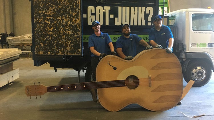 Large acoustic guitar in front of a 1-800-GOT-JUNK? truck Large acoustic guitar in front of a 1-800-GOT-JUNK? truck